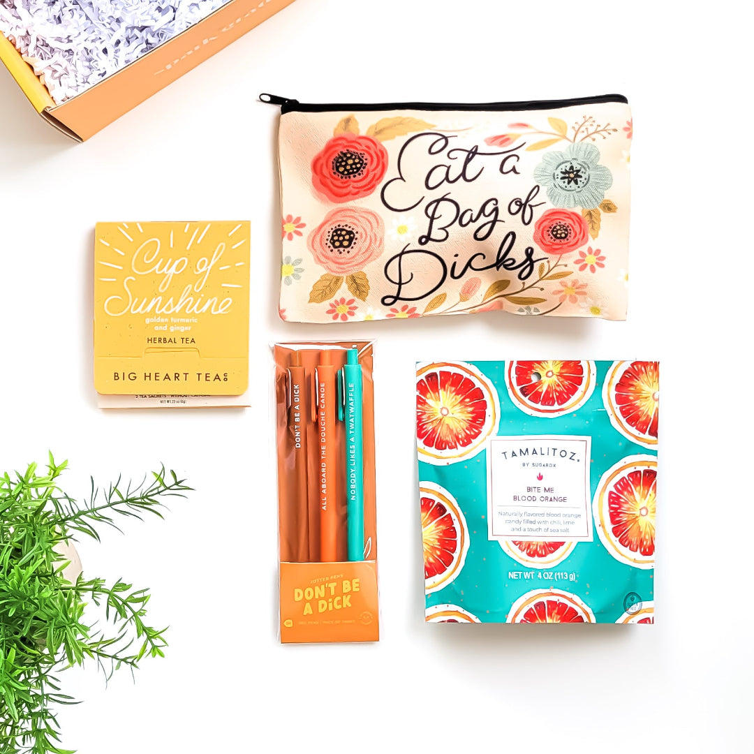 "Don't Be..." Gift Box – A sassy and hilarious gift featuring a cheeky canvas bag, snarky jotter pens, citrusy tea, and tangy peach candy. Perfect for playful pranks and bold personalities.