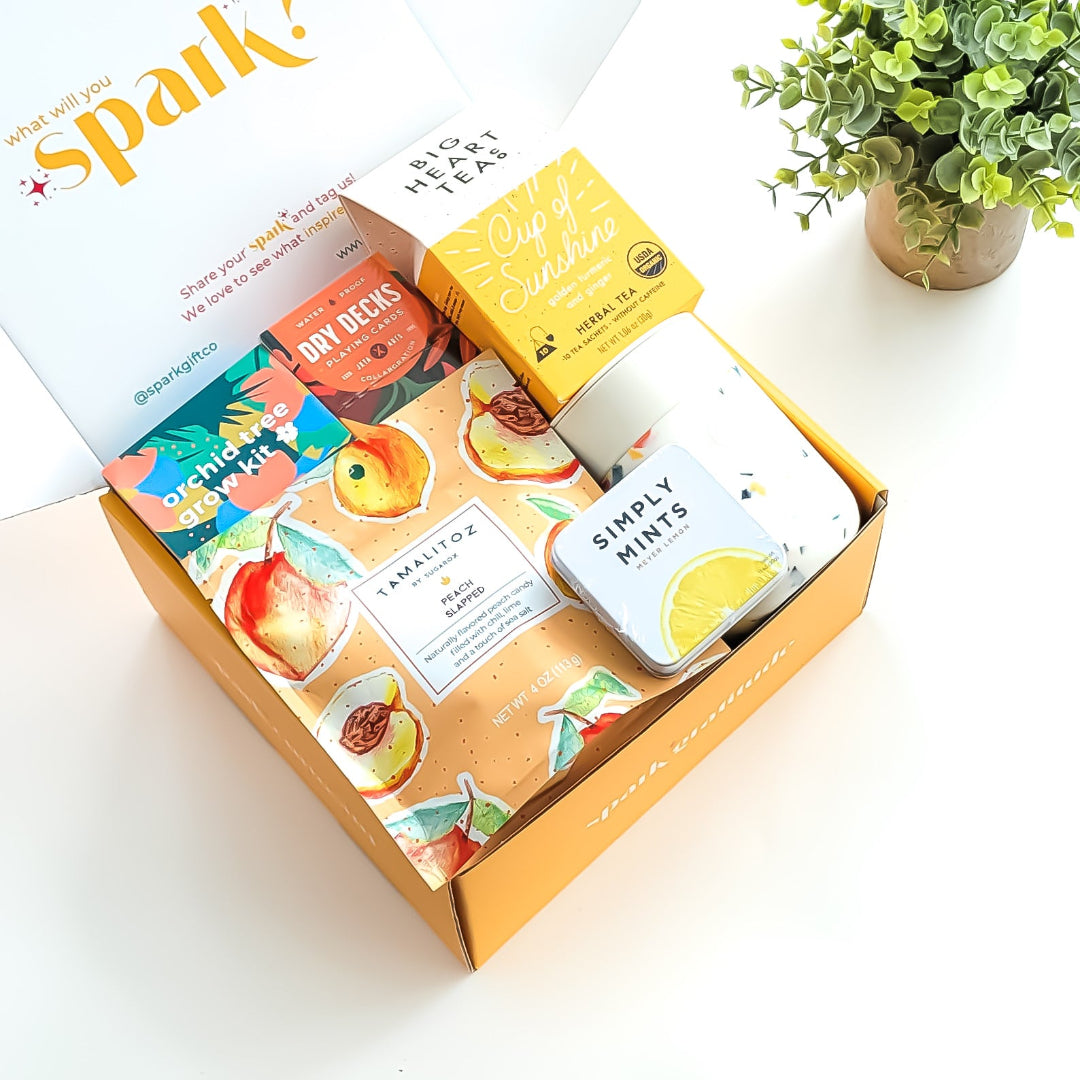 Golden Bloom Gift Box with an orchid tree grow kit, herbal tea sampler, terrazzo ceramic tumbler, assorted lollipop, and peach candy—perfect for nature lovers and thoughtful gifting.