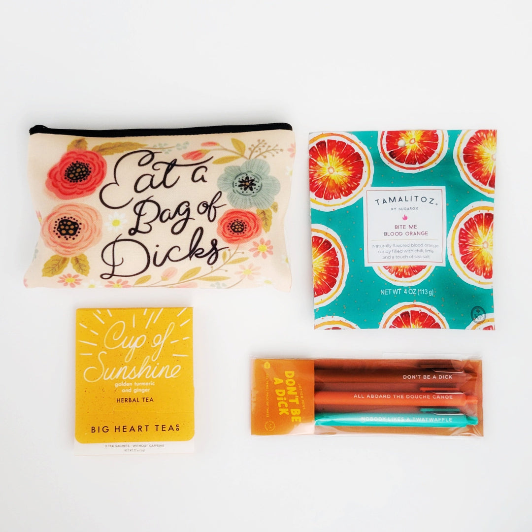 Don’t Be Gift Box with a snarky "Eat a Bag of Dicks" canvas bag, "Don't Be a Dick" jotter pen set, Cup of Sunshine tea sampler, and Bite Me blood orange tamalitz candy—perfect for best friends, office pranks, and lovers of sassy humor. Ships anonymously for extra fun!