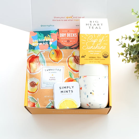 Golden Bloom Gift Box with an orchid tree grow kit, herbal tea sampler, terrazzo ceramic tumbler, assorted lollipop, and peach candy—perfect for nature lovers and thoughtful gifting.