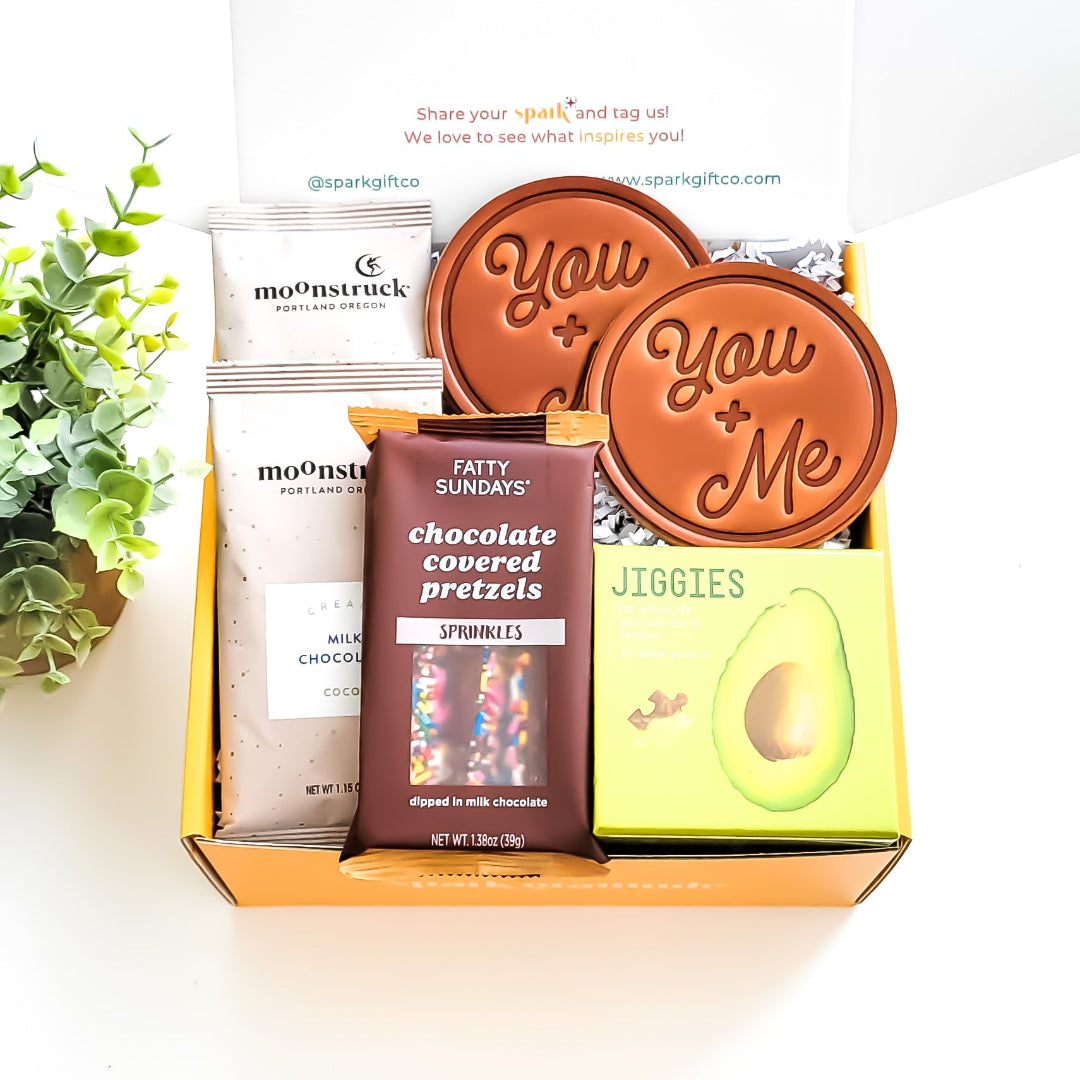 Just the Two of Us Gift Box with hot chocolate, hand-stamped leather coasters, chocolate-covered pretzel sticks, and a 35-piece puzzle—perfect for couples and cozy nights in.