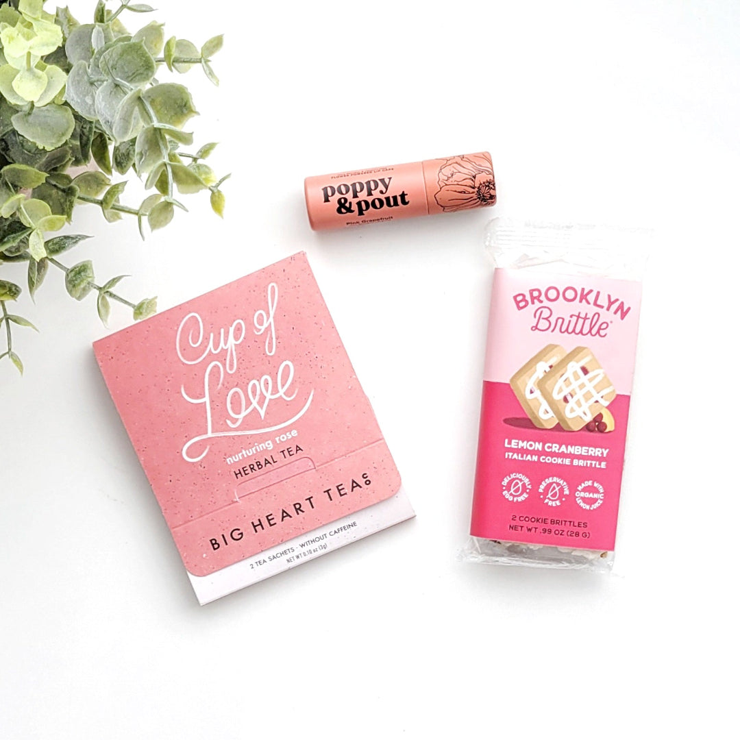 XOXO Gift Box with Cup of Love rose tea, pink grapefruit lip balm, and cookie brittle, perfect for self-care and thoughtful gifting.