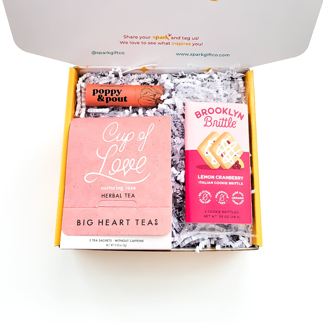 XOXO Gift Box with Cup of Love rose tea, pink grapefruit lip balm, and cookie brittle, perfect for self-care and thoughtful gifting.